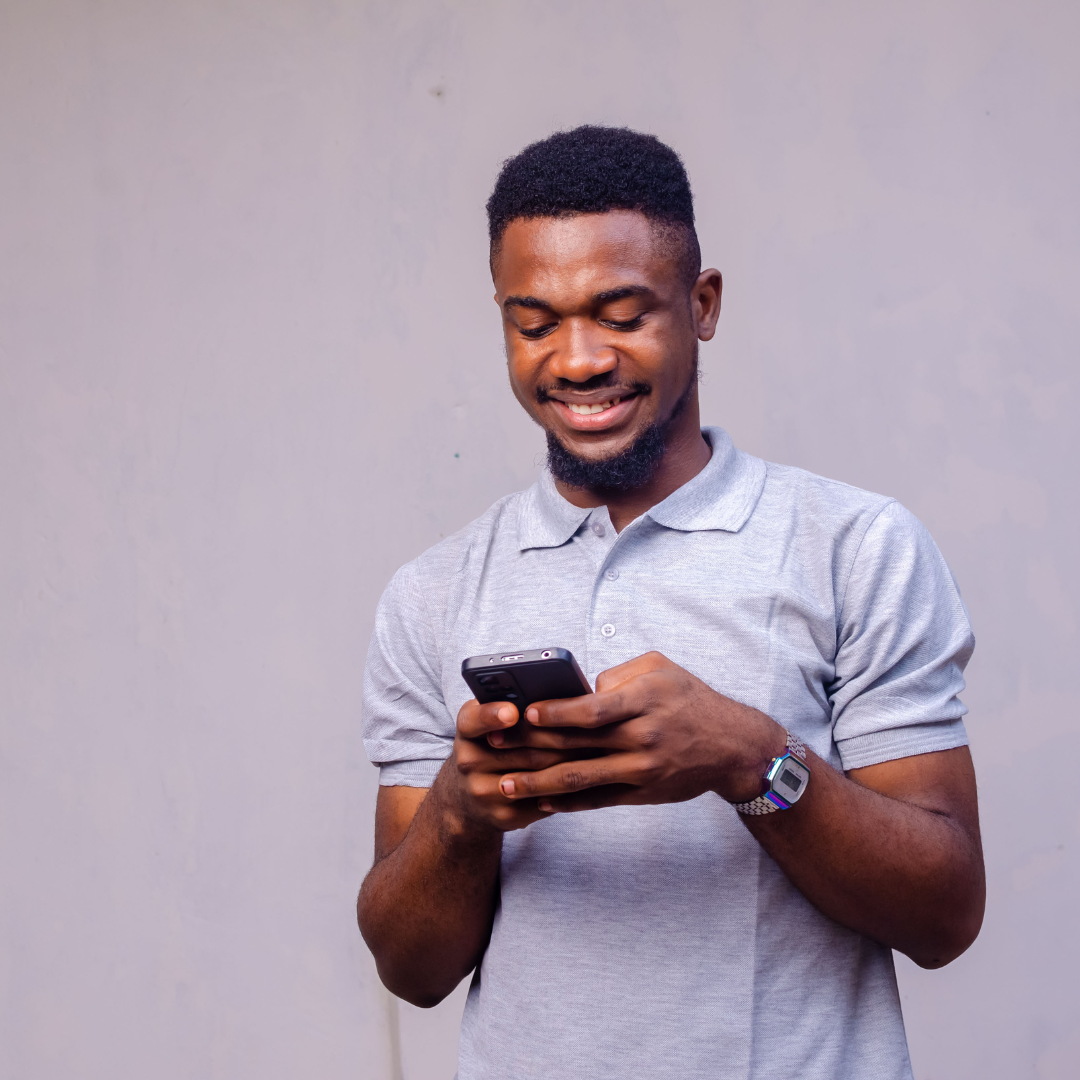 Homem mexendo no celular e sorrindo